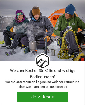 Drei Männer sitzen vor Primus Kocher bei kalten Bedingungen