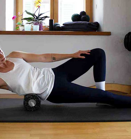 Für das Faszientraining am unteren Rücken nimmst Du eine leicht seitliche Position ein. Rolle gleichmäßig ab.