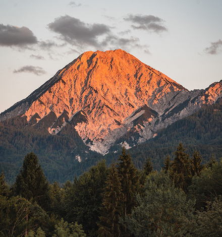 Der markante Mittagskogel leuchtet in der Abendsonne &uuml;ber dem Faaker See.