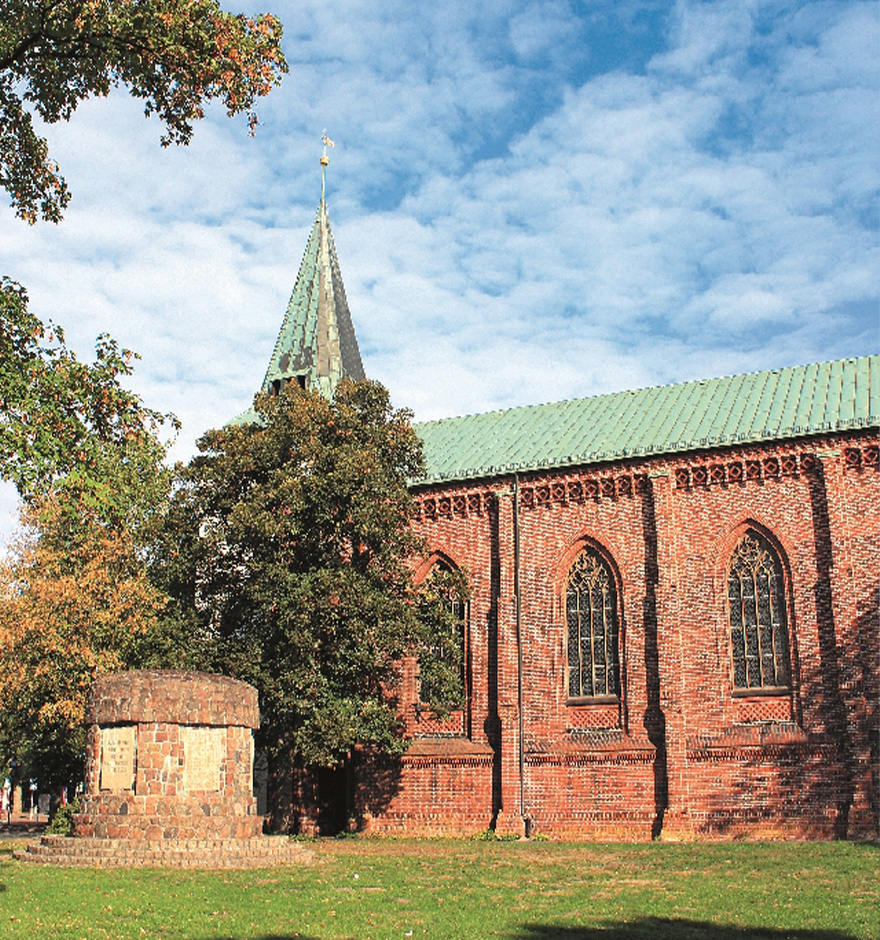 Teilansicht der neugotischen Rotenburger Stadtkirche mit Gefallenen-Denkmal.
